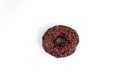a sweet donut, covered with chocolate and decorated with brown powder. depicted in the center on a white background. top view Royalty Free Stock Photo
