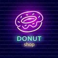 Donut shop neon logo sign on dark brick wall background