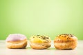 Donuts. Assorted donuts lying on a white table on green background. ÃÂ¡oncept sweet food Royalty Free Stock Photo