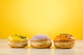 Donuts. Assorted donuts lying on a white table on yellow background. ÃÂ¡oncept sweet food Royalty Free Stock Photo