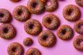 Donuts with bright multi-colored sprinkles, on a purple background.