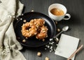 donuts with caramel and hazelnuts, cup of coffee on the rustic table Royalty Free Stock Photo