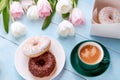 Donuts, coffee and tulips on a blue wooden background. Royalty Free Stock Photo