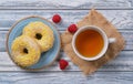 Donuts, cup of green chamomile tea, fresh juicy red raspberries Royalty Free Stock Photo