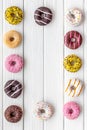 Donuts of different flavors for breakfast frame on white wooden background top view space for text