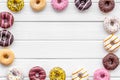 Donuts of different flavors for breakfast frame on white wooden background top view space for text