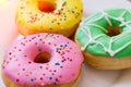 Donuts with a glaze on a white plate. Colored sweet donuts