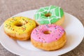 Donuts with a glaze on a white plate. Colored sweet donuts