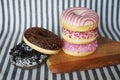 Donuts with pink and chocolate icing on a wooden board with a striped background Royalty Free Stock Photo