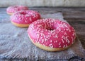 Donuts with pink frosting on the table Royalty Free Stock Photo