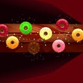 Donuts of various colors on a wooden table