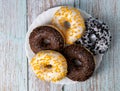 Donuts on a white plate on a wooden table