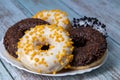 Donuts on a white plate on a wooden table