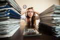 Doomed accountant against big stacks of documents