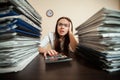 Doomed accountant against big stacks of documents Royalty Free Stock Photo