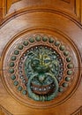 Door with a bronze knocker in the shape of a lion's head