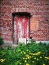 Door in a building made of bricks in front of the green plants Royalty Free Stock Photo