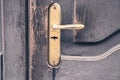 Door handle of gold color with an old wooden door Royalty Free Stock Photo