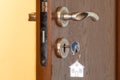 Door handle with inserted key in the keyhole and house icon on it Royalty Free Stock Photo