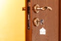 Door handle with inserted key in the keyhole and house icon on it Royalty Free Stock Photo