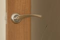 door handle and keyhole on wooden door with glass, close up image