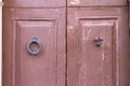 Door handle and knocker of a red ruined door Royalty Free Stock Photo