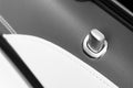 Door handle with lock control buttons of a luxury passenger car. Black leather interior of the luxury modern car. Modern car inter