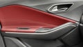 Door handle with Power window control buttons of a luxury passenger car. Red leather interior of the luxury modern car. Modern car