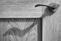 Door handle and shadow on wooden door. Monochrome.