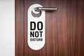 Door of hotel room with sign do not disturb