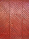 A door inside a huge old patio door of a village house made of red wooden slats Royalty Free Stock Photo