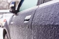 Door, knob, keyhole of car covered with snow and ice after a snowfall Royalty Free Stock Photo