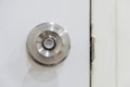 Door knob is made of stainless steel, mounted on a white wooden Royalty Free Stock Photo