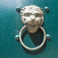 A door knocker is a fixture on the front door of a house. It is made of metal and has the form of a ring, which is