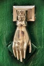 Door knocker with hand shape on green wooden door Royalty Free Stock Photo