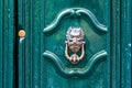 Door knocker like antique head on the entrance of a house, Old ornate metal door handle Royalty Free Stock Photo