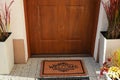 Door mat with word Welcome on street tiles near entrance