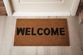 Door mat with word Welcome on wooden floor in hall, above view Royalty Free Stock Photo