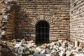 The door is from the metal grille of an ancient antique building, a castle of stone with sprawling blocks Royalty Free Stock Photo