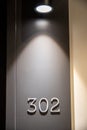 Door number 302 under a mysterious light
