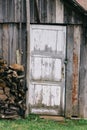 The door of the old barn with peeling off white paint.