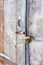 Old dilapidated door closed with padlock