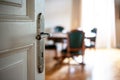 Door open close up. Retro doorknob on white door, blur floor parquet, classy house interior Royalty Free Stock Photo