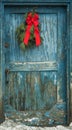 Door with peeling blue paint with holiday bough