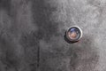 Door peephole on a dark gray metal door.