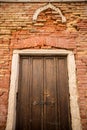 Door in Red Brick Wall in Venice. Italy. Royalty Free Stock Photo