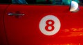 Door of a red car with number 8 drawn on it