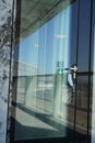 A door with sign exit with a face mask suspended on a door handle in a corporate building, close up. A reminder of safety measures