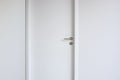 Door with stainless steel handle on white wood door. Royalty Free Stock Photo