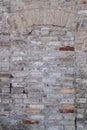 Door walled up with battered bricks and overhead arc